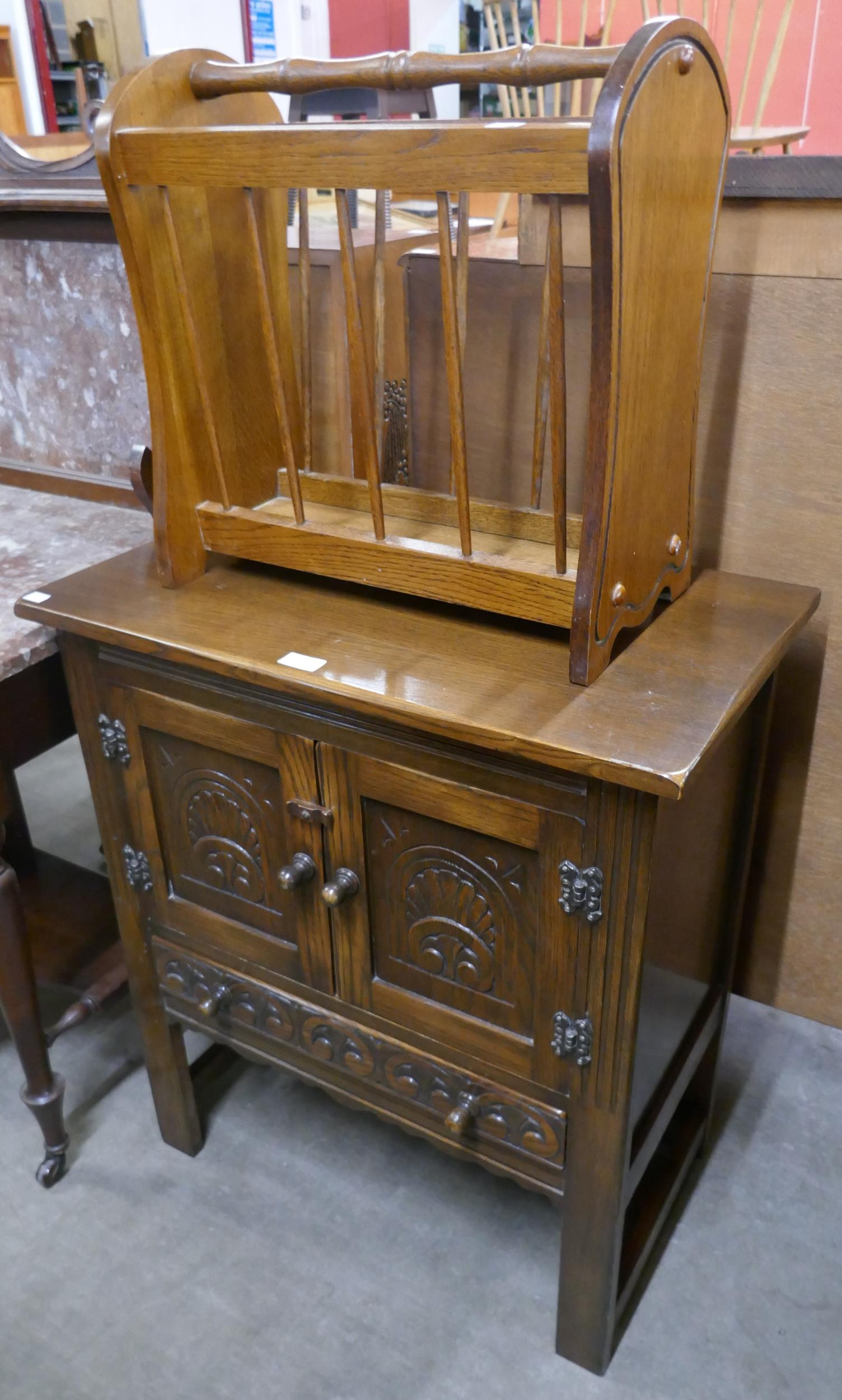 A carved oak credence cupboard and a magazine rack