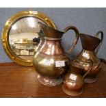 An Arts and Crafts mirror and copper and brass jugs