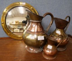 An Arts and Crafts mirror and copper and brass jugs