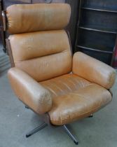 A Charles & Ray Eames style teak and tan leather revolving lounge chair