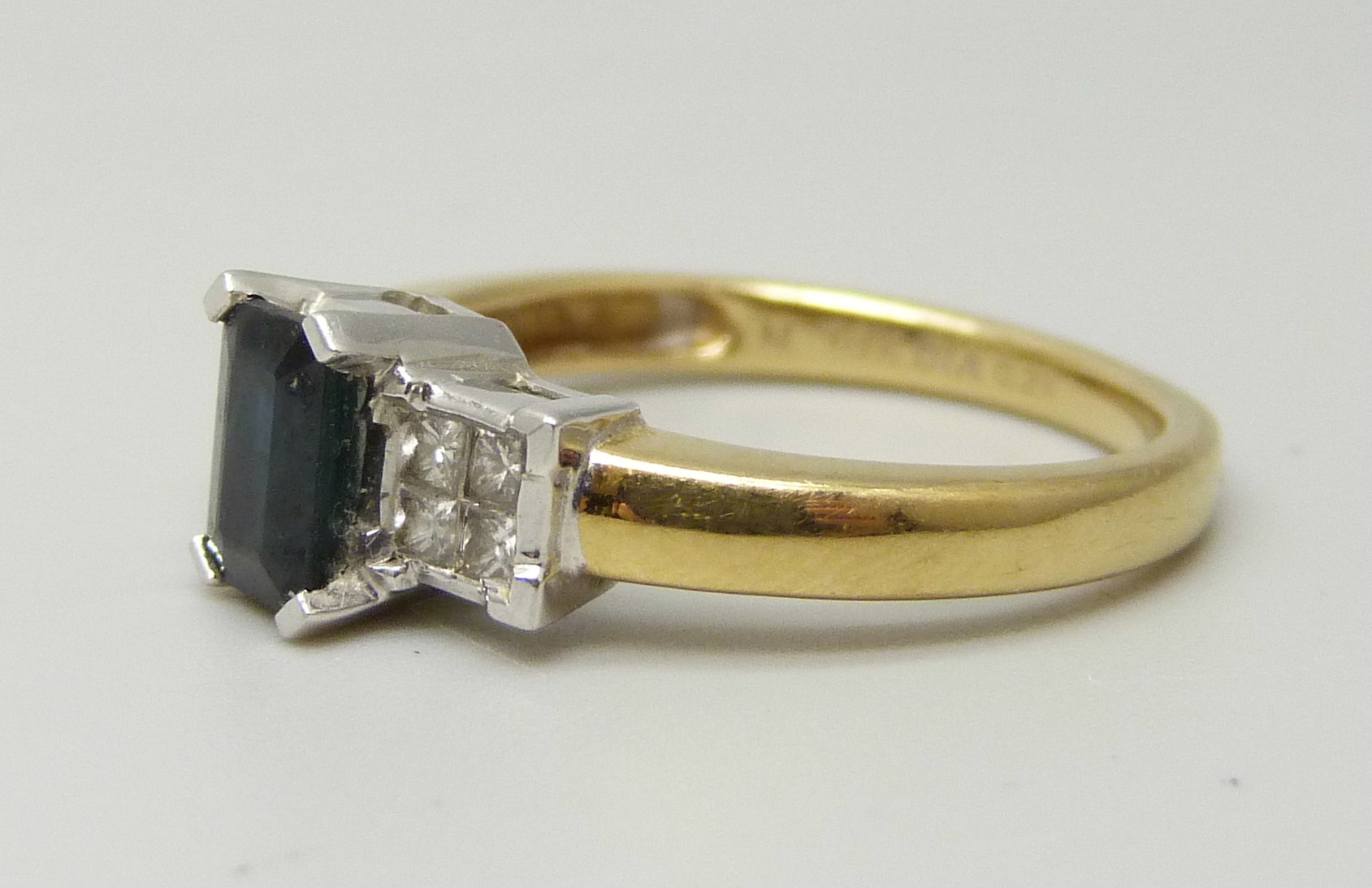 An 18ct yellow gold ring set with a central sapphire (6 x 4mm) and four princess cut diamond on each - Image 2 of 4