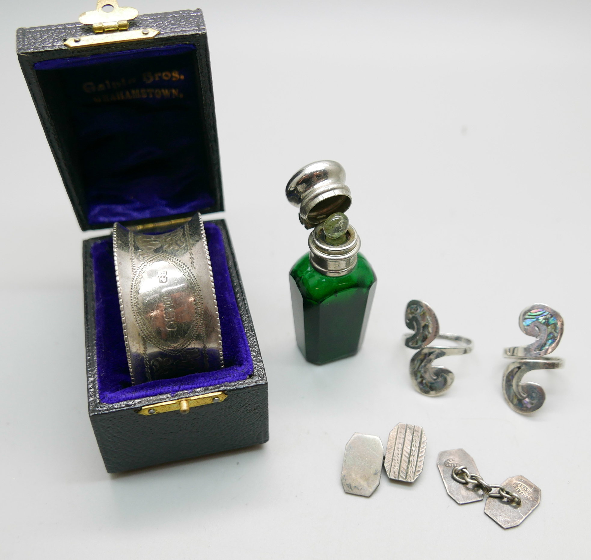 A silver boxed napkin ring, 25g, a green glass scent bottle with inner stopper and Stanhope