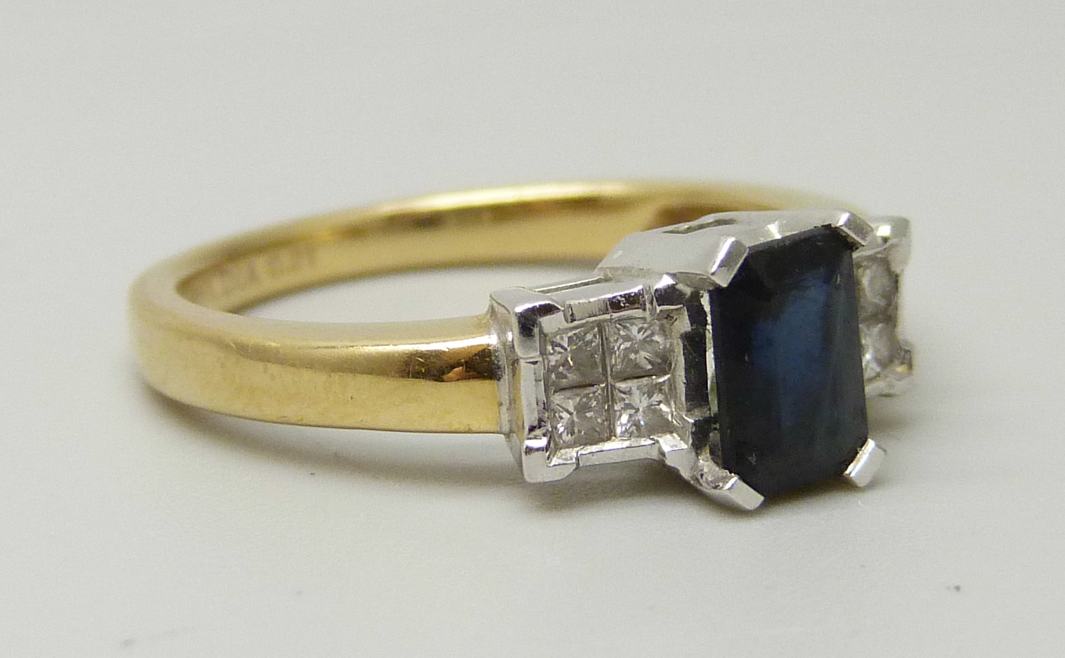 An 18ct yellow gold ring set with a central sapphire (6 x 4mm) and four princess cut diamond on each - Image 3 of 4