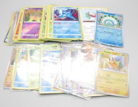 A collection of British Pokemon cards, some in protective sleeves, some loose