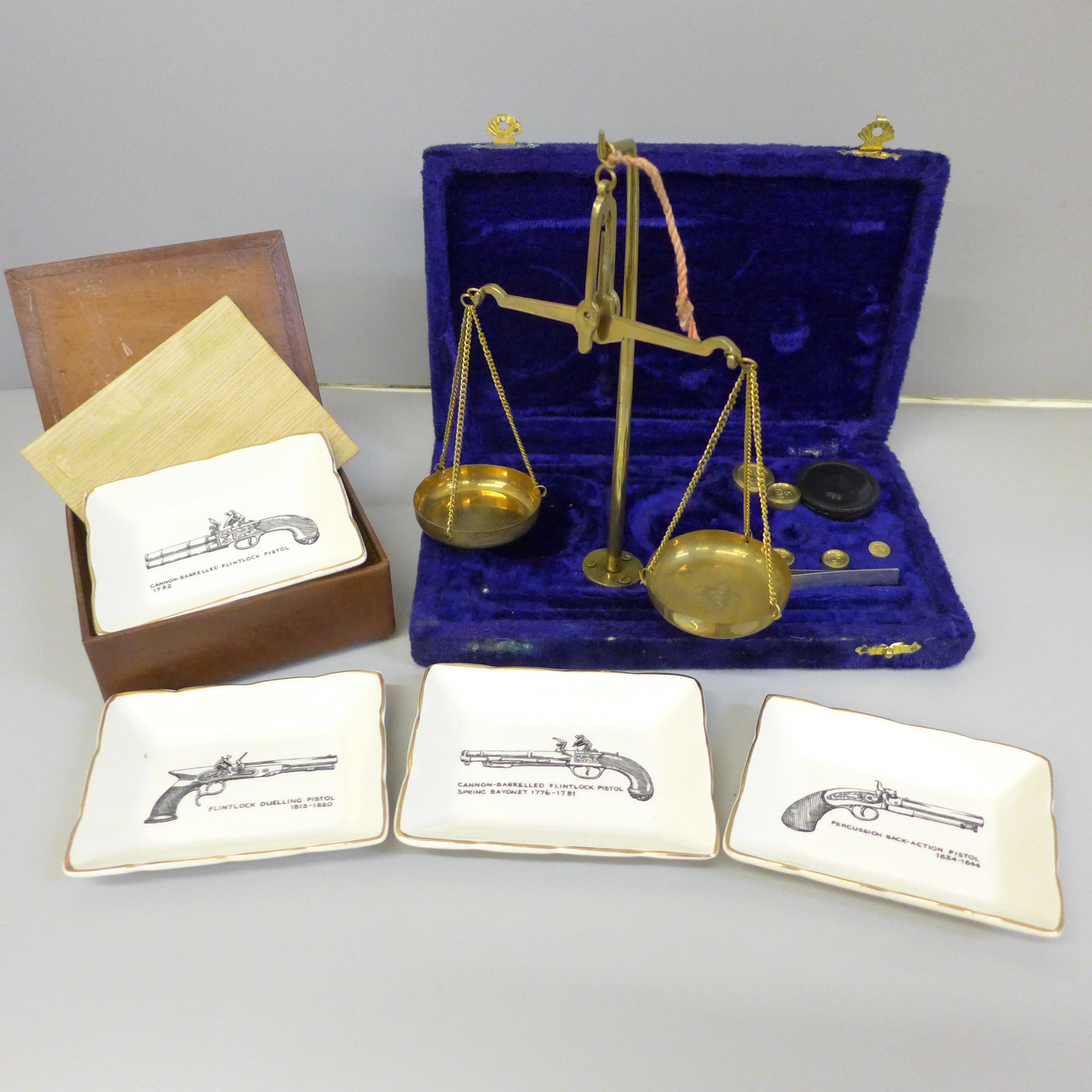 A small set of brass balance scales and a set of Sandland ware pistol trinket dishes, boxed