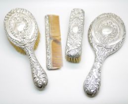 A four piece silver dressing table set, Birmingham 1906, a mirror, hand brush , hair brush and