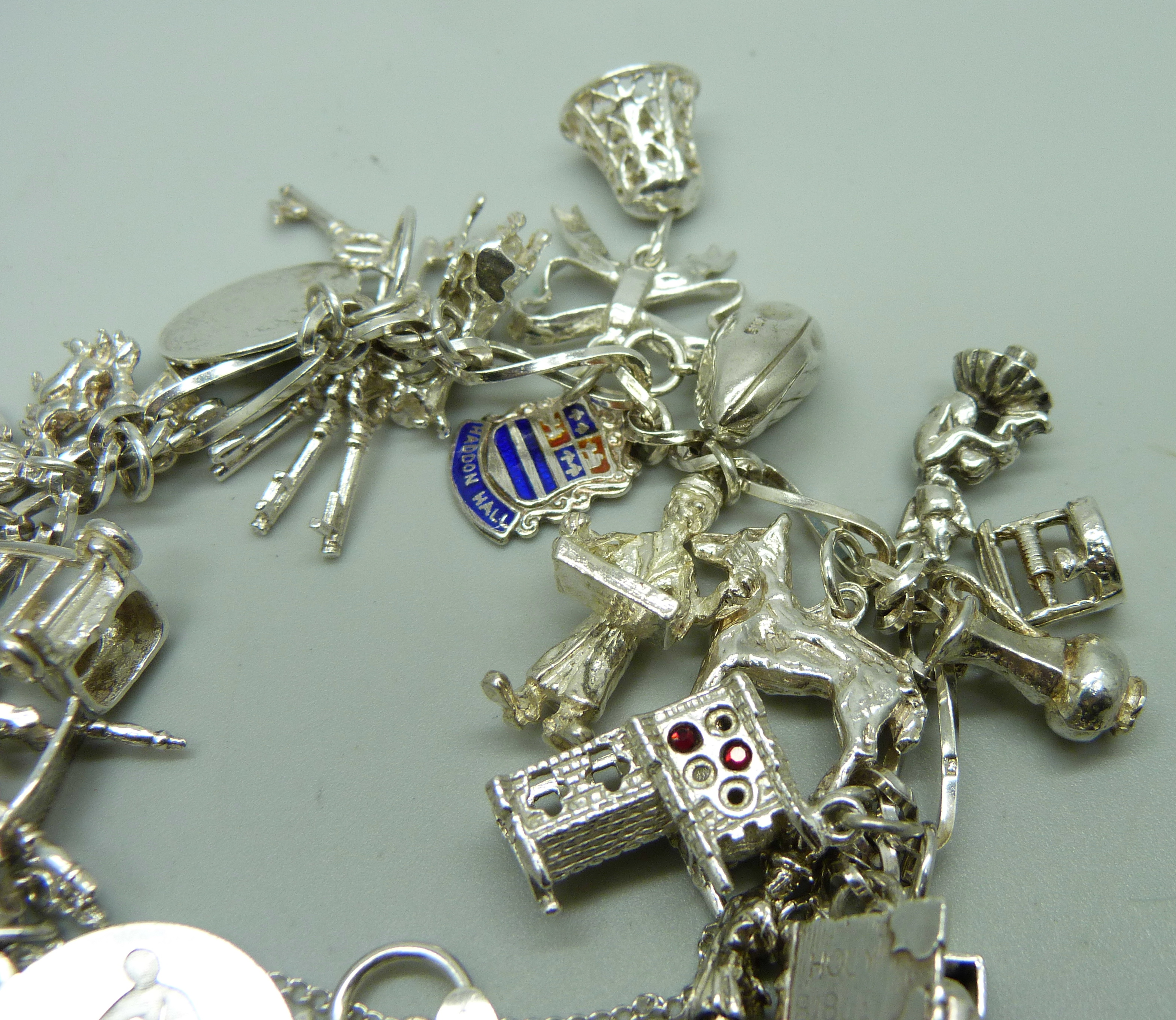 A silver charm bracelet with 26 charms, 63.9g - Image 2 of 3