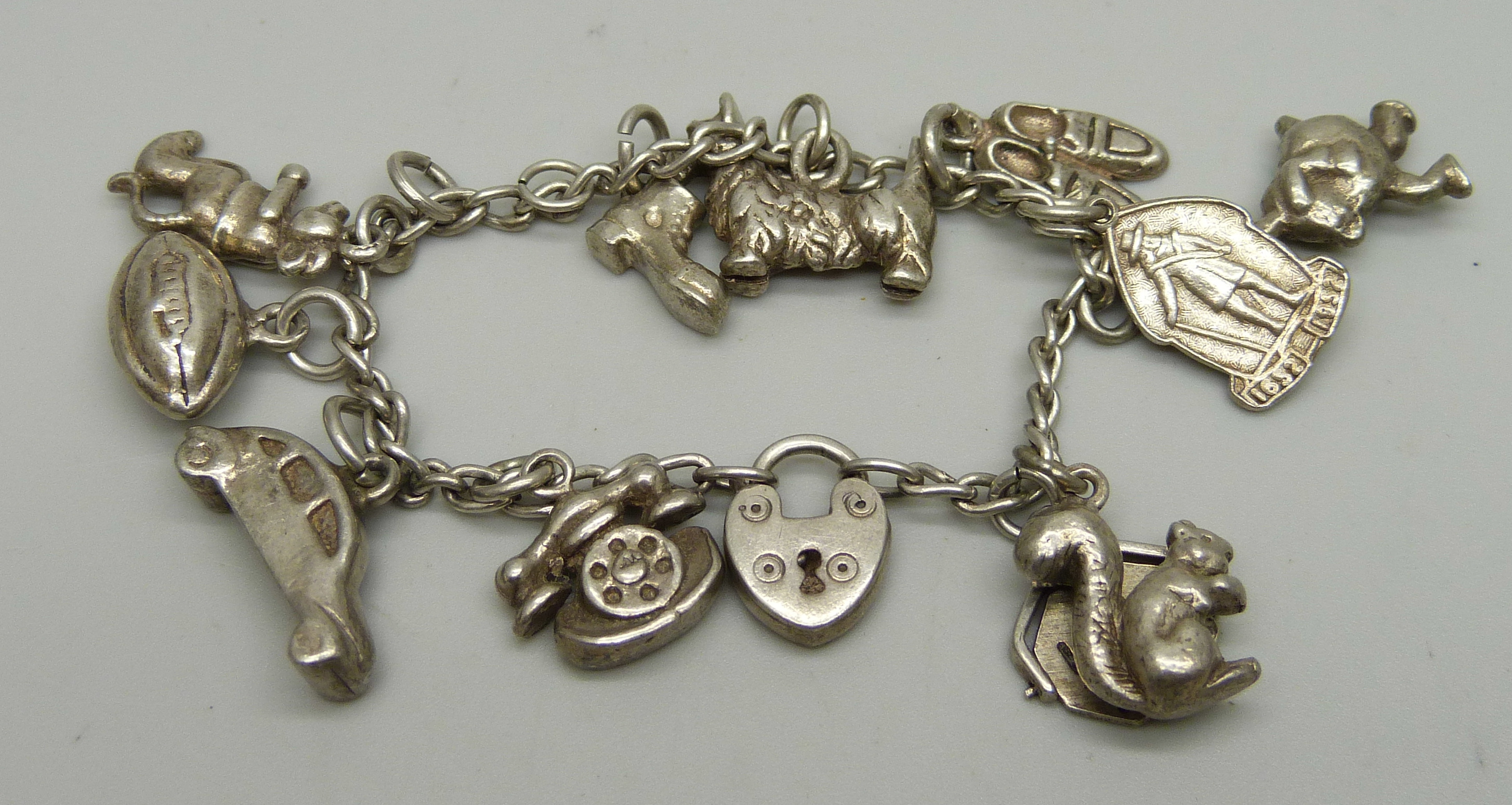 A small silver charm bracelet with nine charms, 42.6g