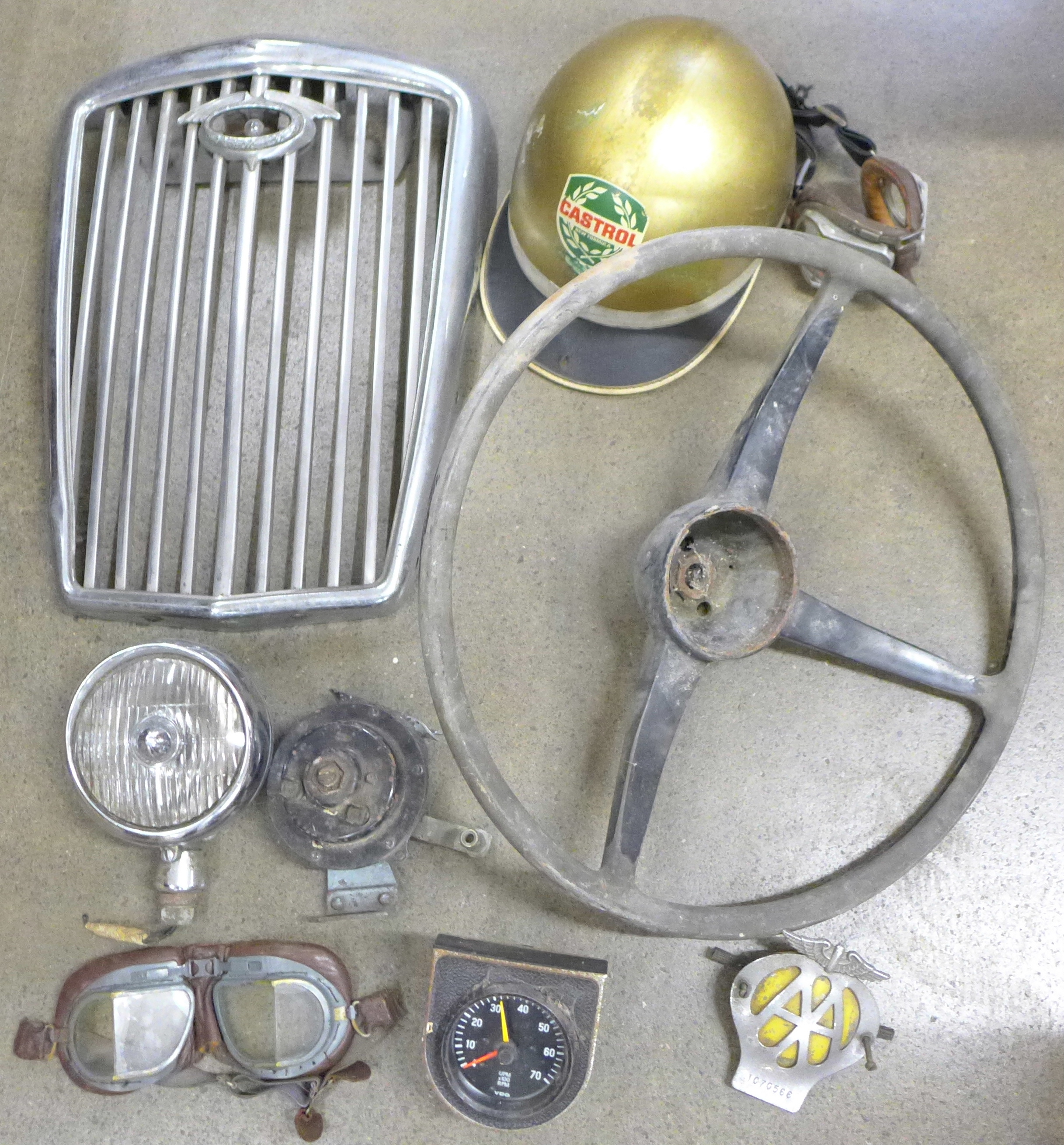 A collection of car parts, Castrol gold helmet, two pairs of driving goggles, steering wheel, rev