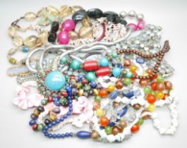 A bag of assorted costume jewellery, blue rhinestone set belt, glass bangles, shell necklaces,
