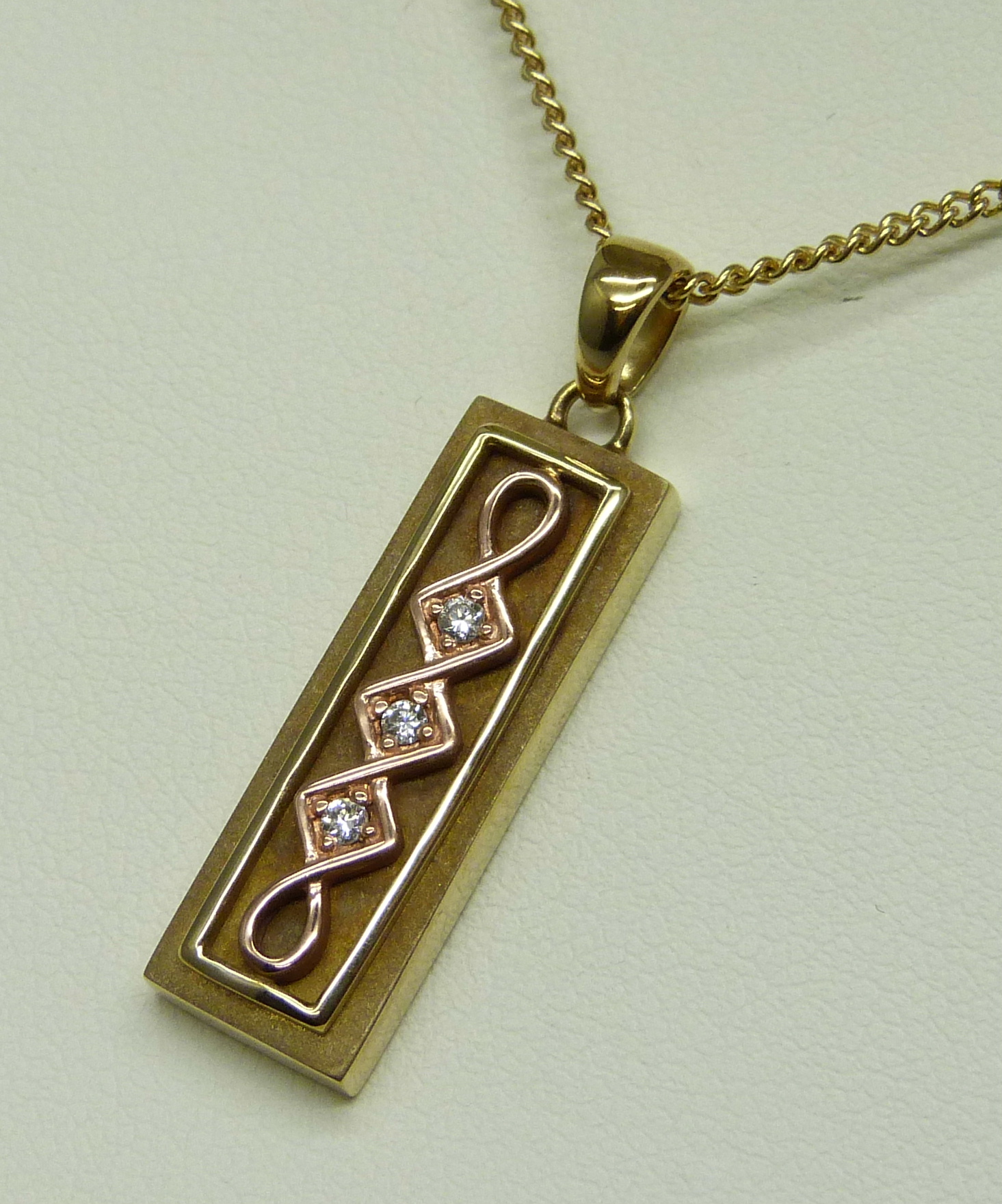 A limited edition Clogau Welsh 9ct gold ingot style pendant of Celtic design, set with three small - Image 2 of 5