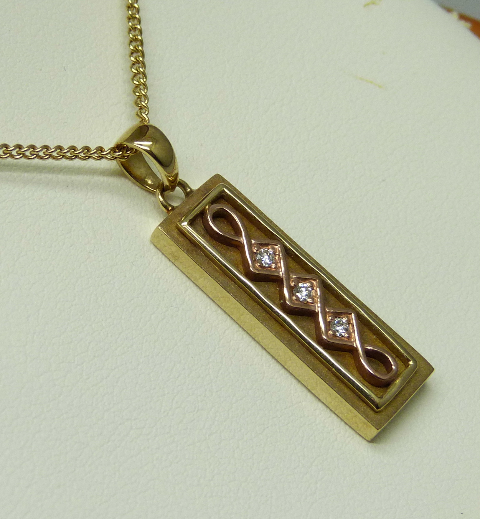 A limited edition Clogau Welsh 9ct gold ingot style pendant of Celtic design, set with three small - Image 3 of 5