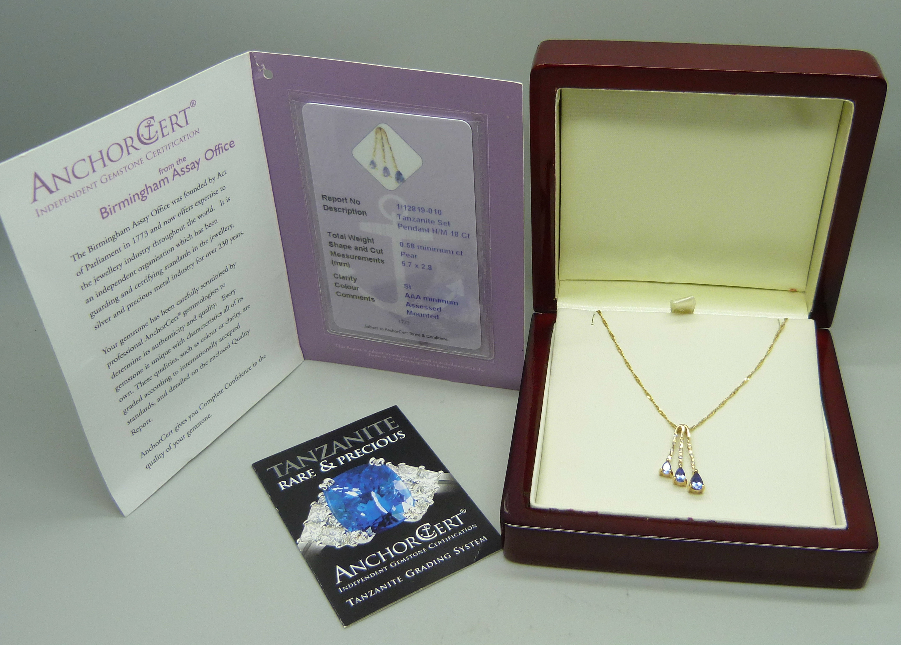 An 18ct yellow gold pendant set with small diamonds and three pear shape grade AAA tanzanite stones,