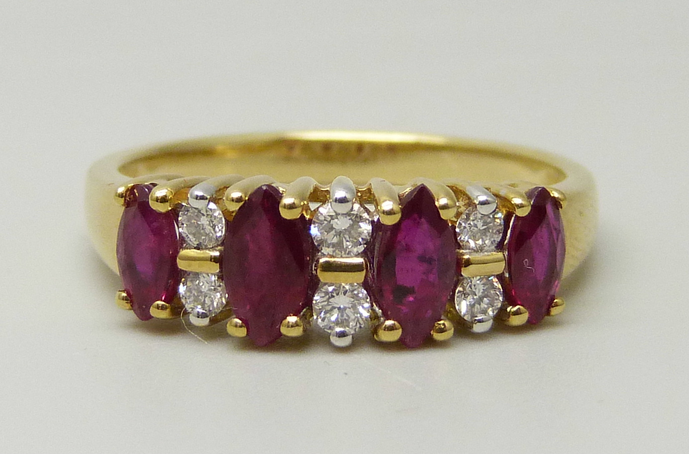 An 18ct yellow gold ring set with four marquise cut rubies and six round brilliant cut diamonds,