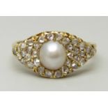 An unmarked yellow metal ring set with a pearl and old cut diamonds, 3.3g, O