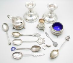 A collection of silver including a pair of candlesticks, condiments, spoons, etc., 137g of weighable