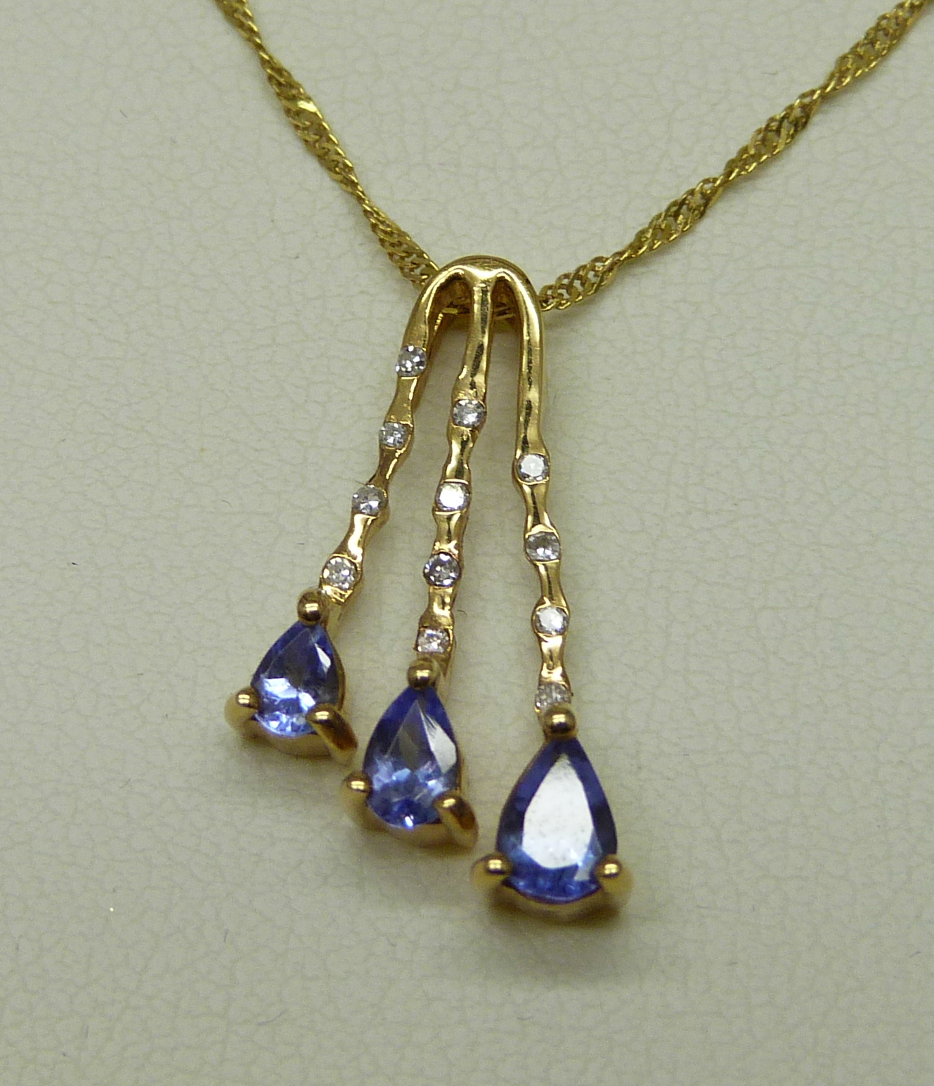 An 18ct yellow gold pendant set with small diamonds and three pear shape grade AAA tanzanite stones, - Image 2 of 6