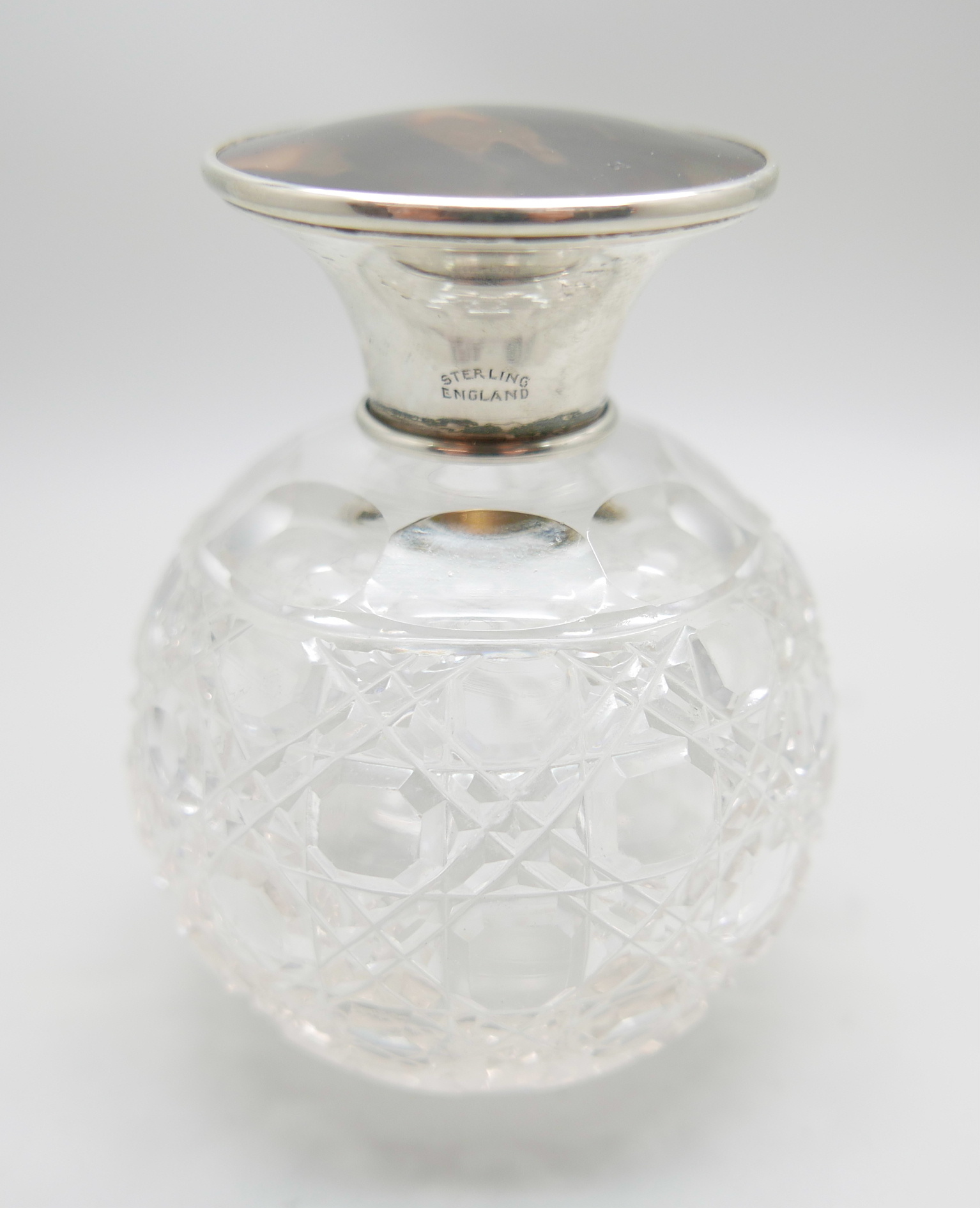 A silver topped globular glass scent bottle