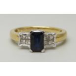 An 18ct yellow gold ring set with a central sapphire (6 x 4mm) and four princess cut diamond on each