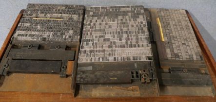 Three trays of metal letter press print type, numbers and letters