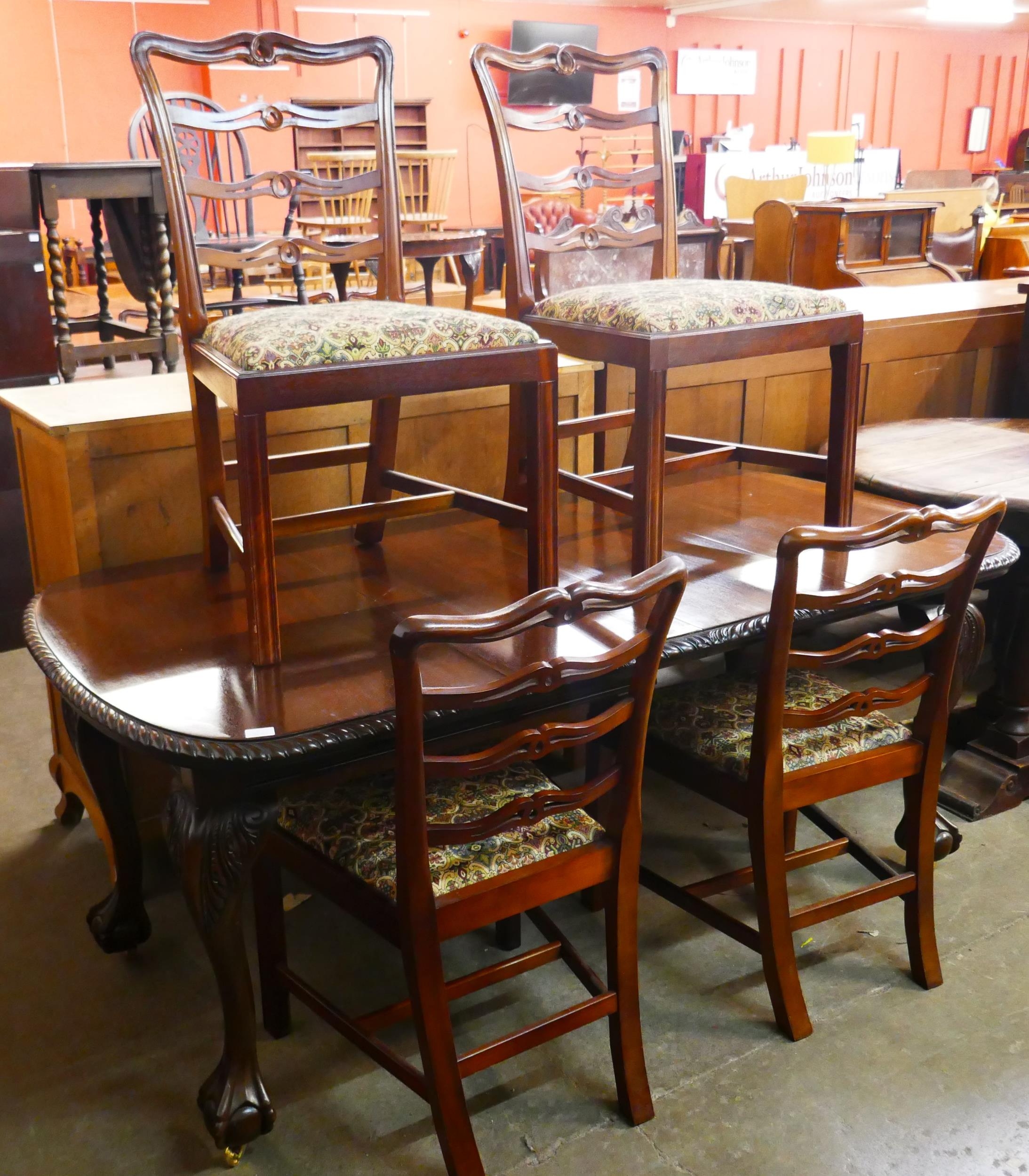 An Edward VII Chippendale Revival carved mahogany dining table and four Hepplewhite style chairs