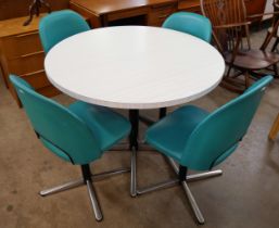 A chrome and Formica circular dining table and four teal vinyl chairs