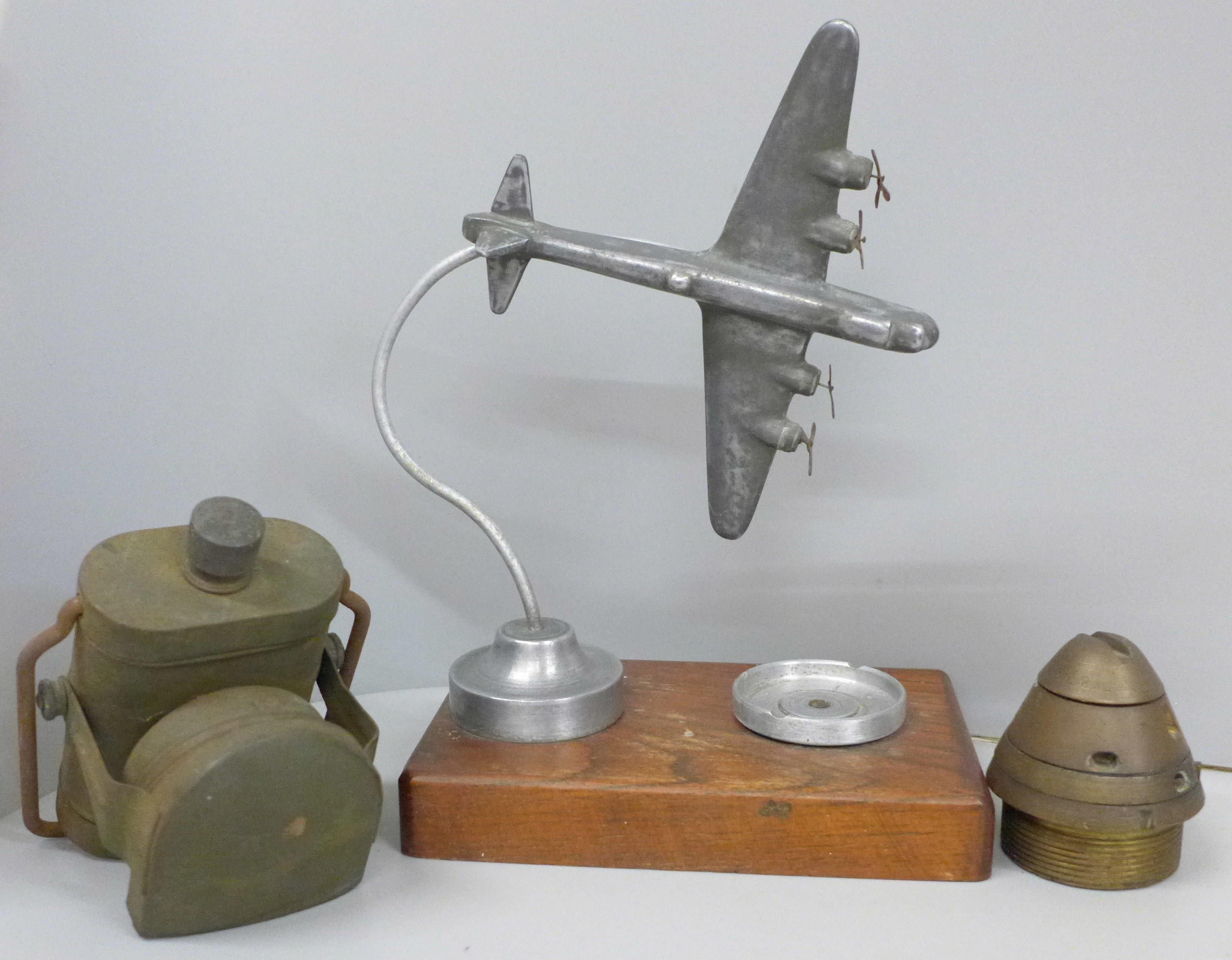 An ash tray with bomber plane decoration, a lamp and an ammunition nose cone