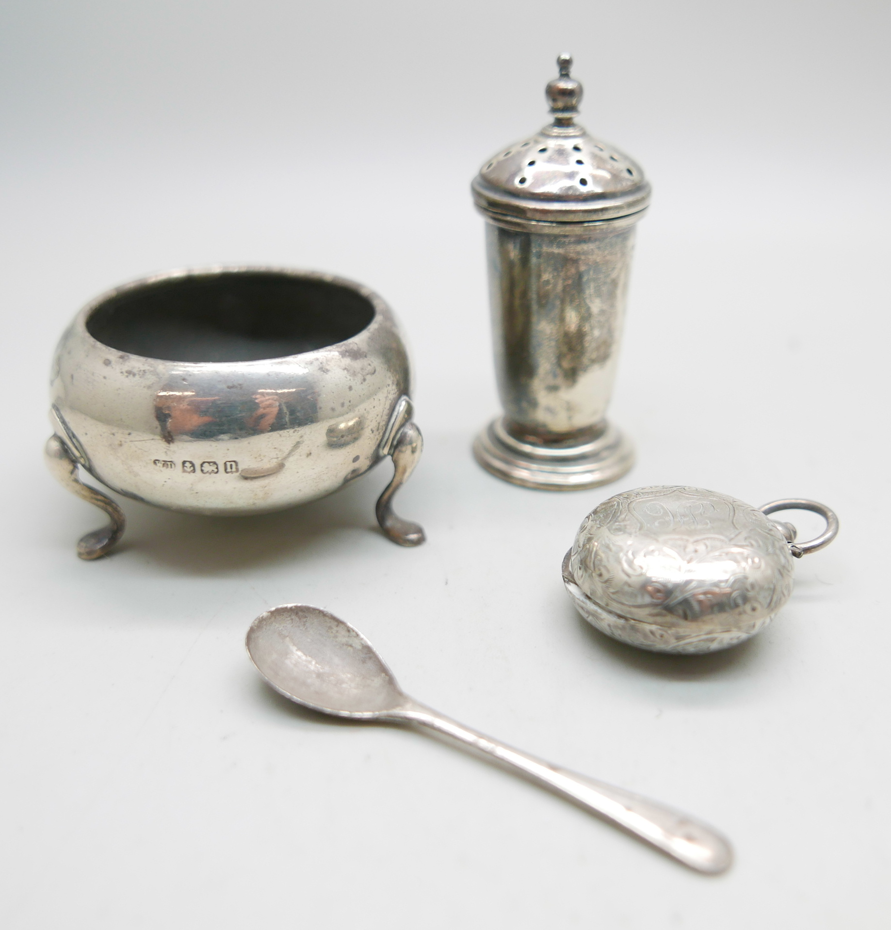A silver salt and spoon, a silver pepper and a silver sovereign case, 74g, case a/f