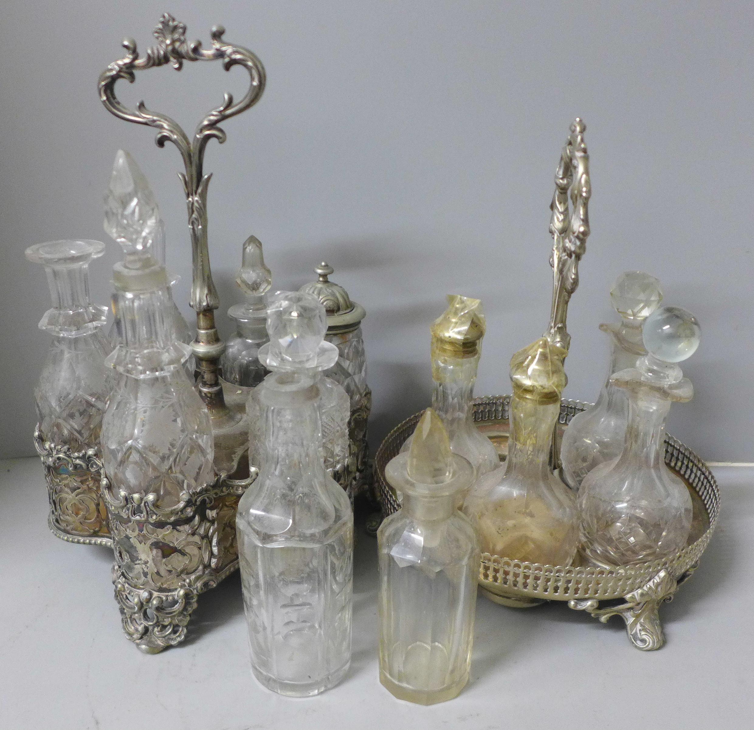 Two plated cruet sets, one six bottle with missing glass bottle and an ornate six bottle cruet set
