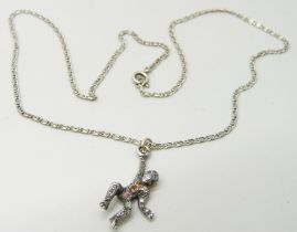An antique diamond set monkey pendant on a chain