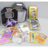 Two tins of Pokemon cards
