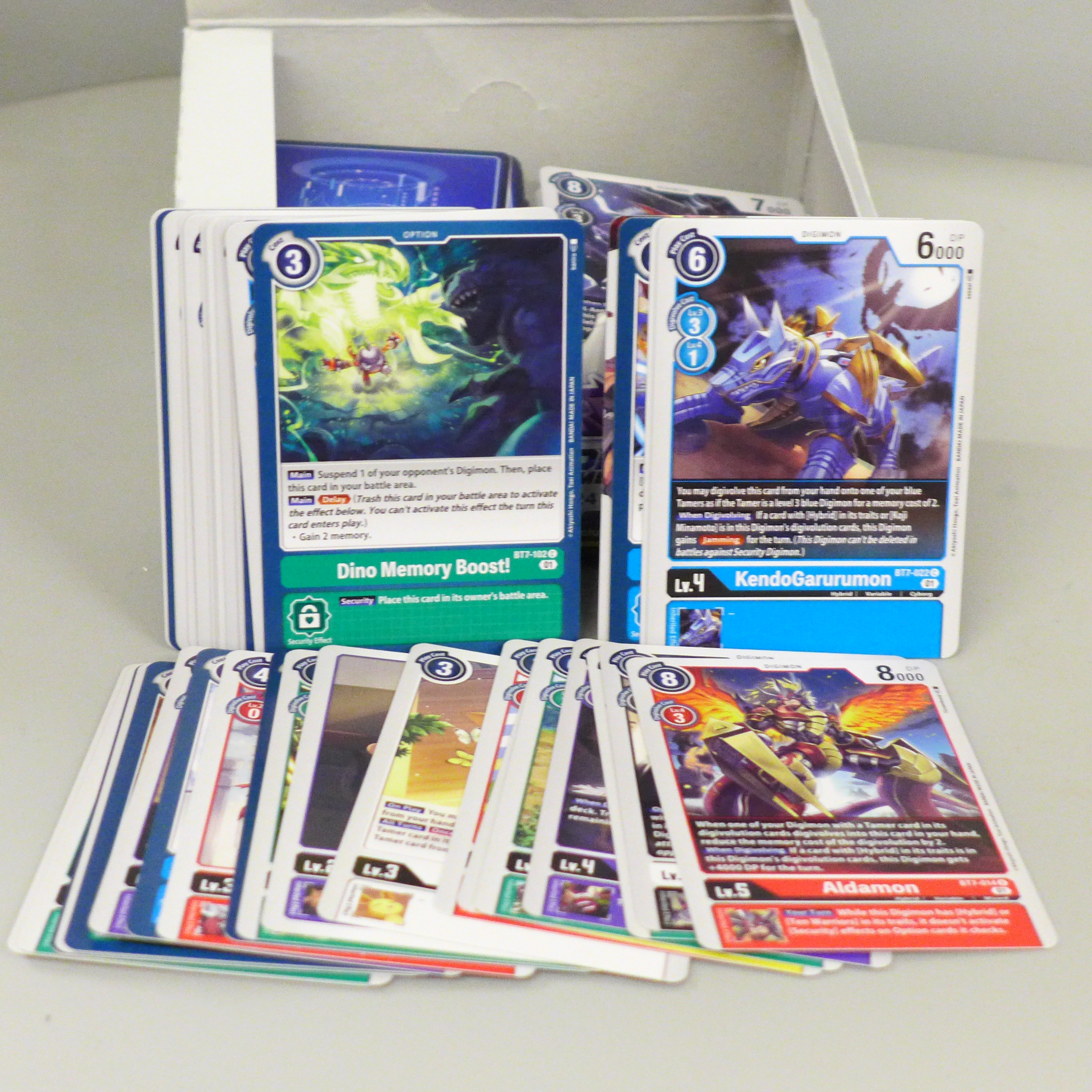 A collection of Digimon cards, with box