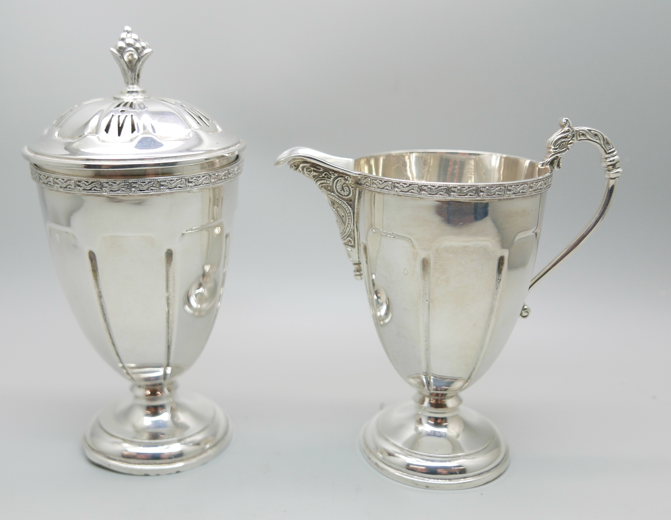 A silver cream jug and a matching sugar shaker by Adie Bros., Birmingham 1935, 207g, (both bases a/