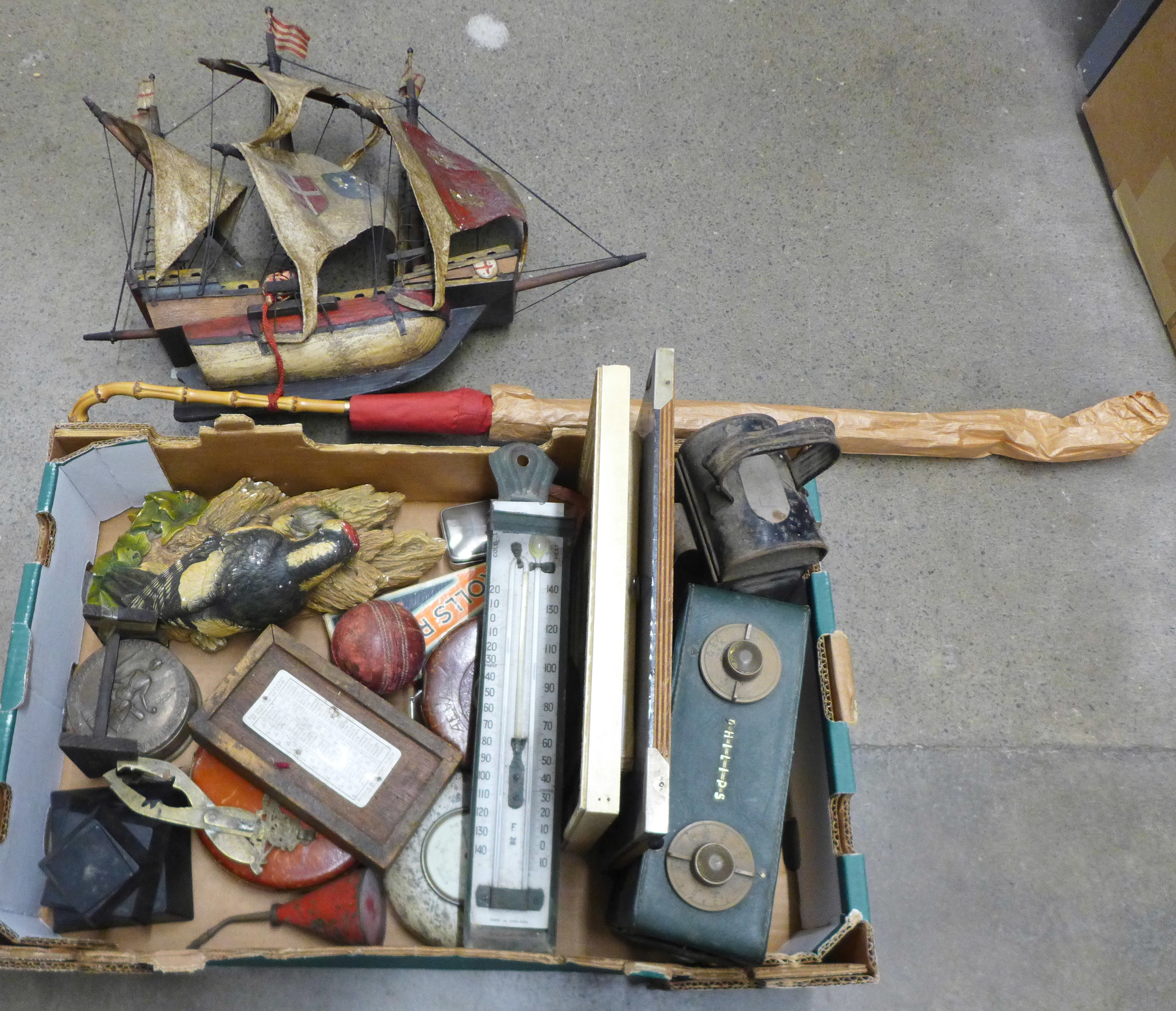 A box of assorted items, surveyor's tape measures, railway lamp, woodpecker figure, lady's umbrella,