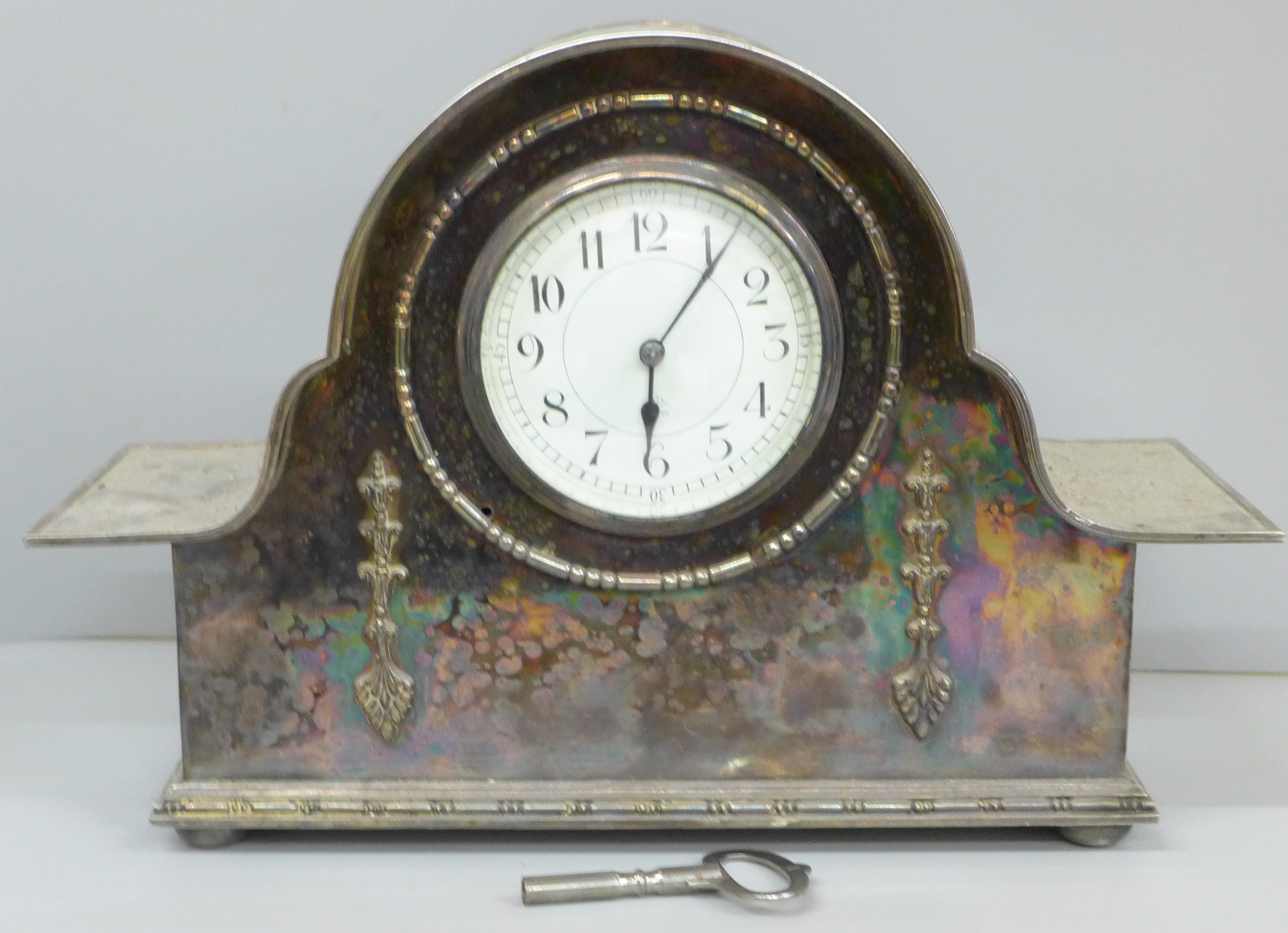 A silver plated mantel clock with French movement, 32cm wide, with key