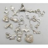 Twenty-four silver charms, 50g