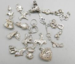 Twenty-four silver charms, 50g