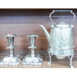 A silver plate coffee pot on stand, on paw feet and crest plate and a pair of plated candlesticks