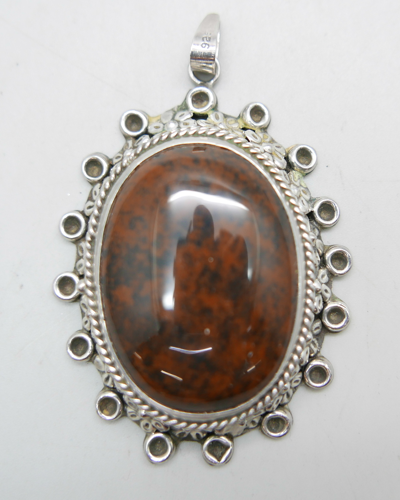 A large hallmarked silver and stone set pendant, London import mark for 1977, 48mm wide