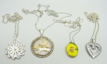 Four silver pendants and chains
