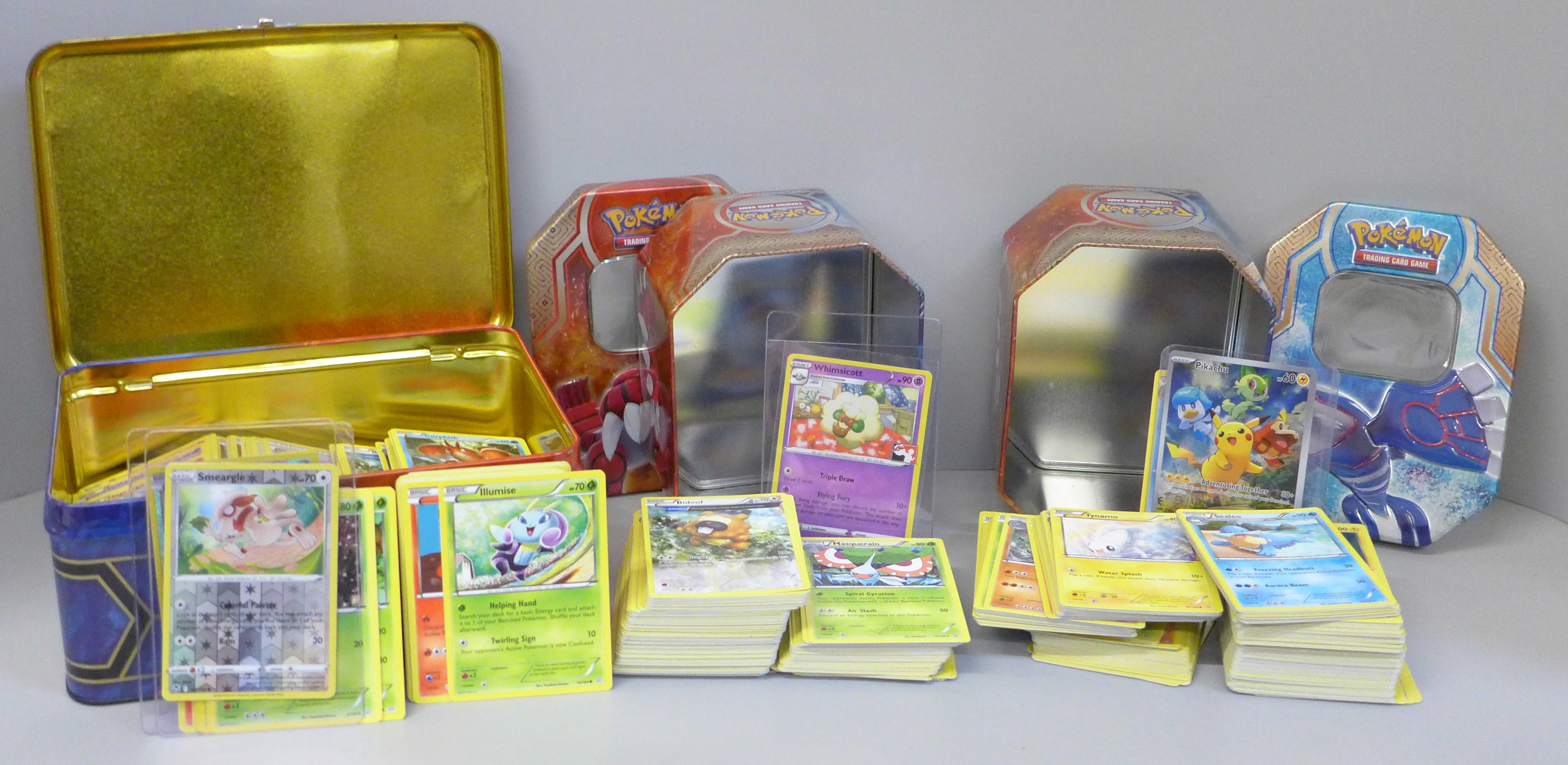 A large quantity of Pokemon cards in collectors tins