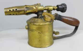 A 1920s brass blow lamp with wooden handle