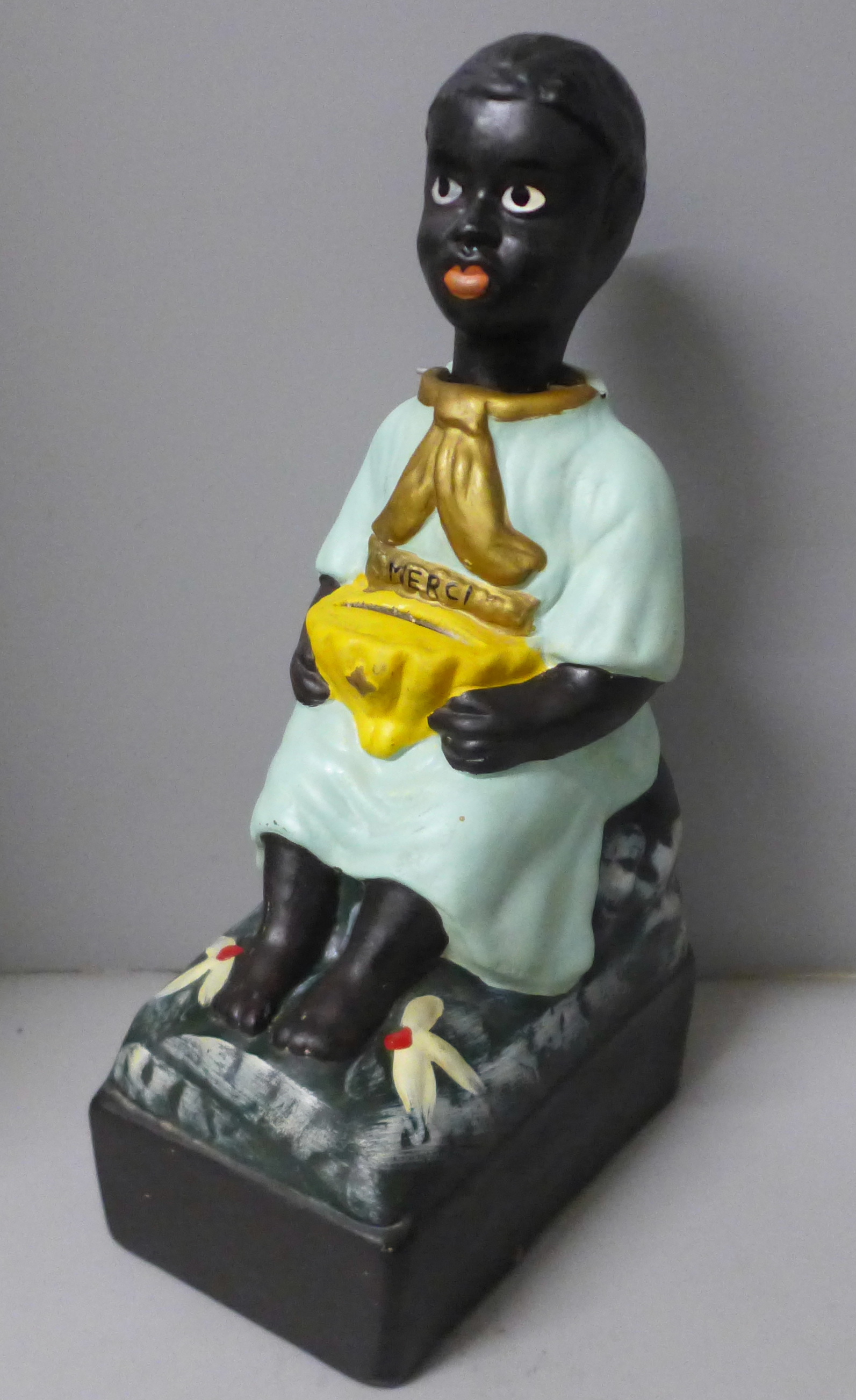 A French charity money box in the form of a seated child with rocking head