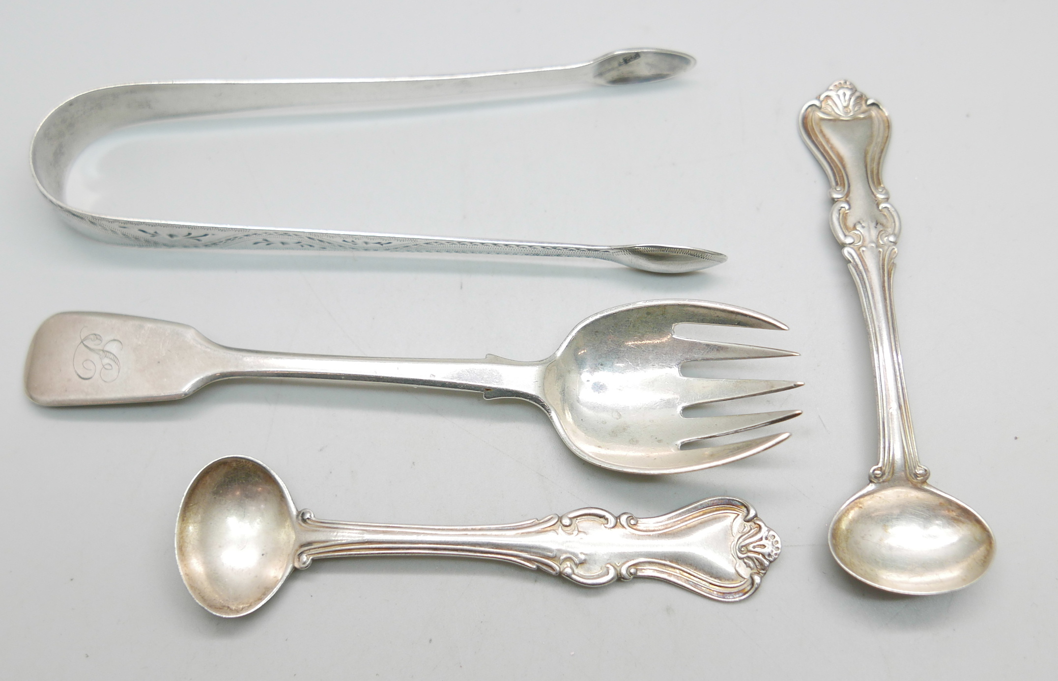 A pair of silver sugar bows, a pair of Victorian Scottish silver mustard spoons and a Victorian
