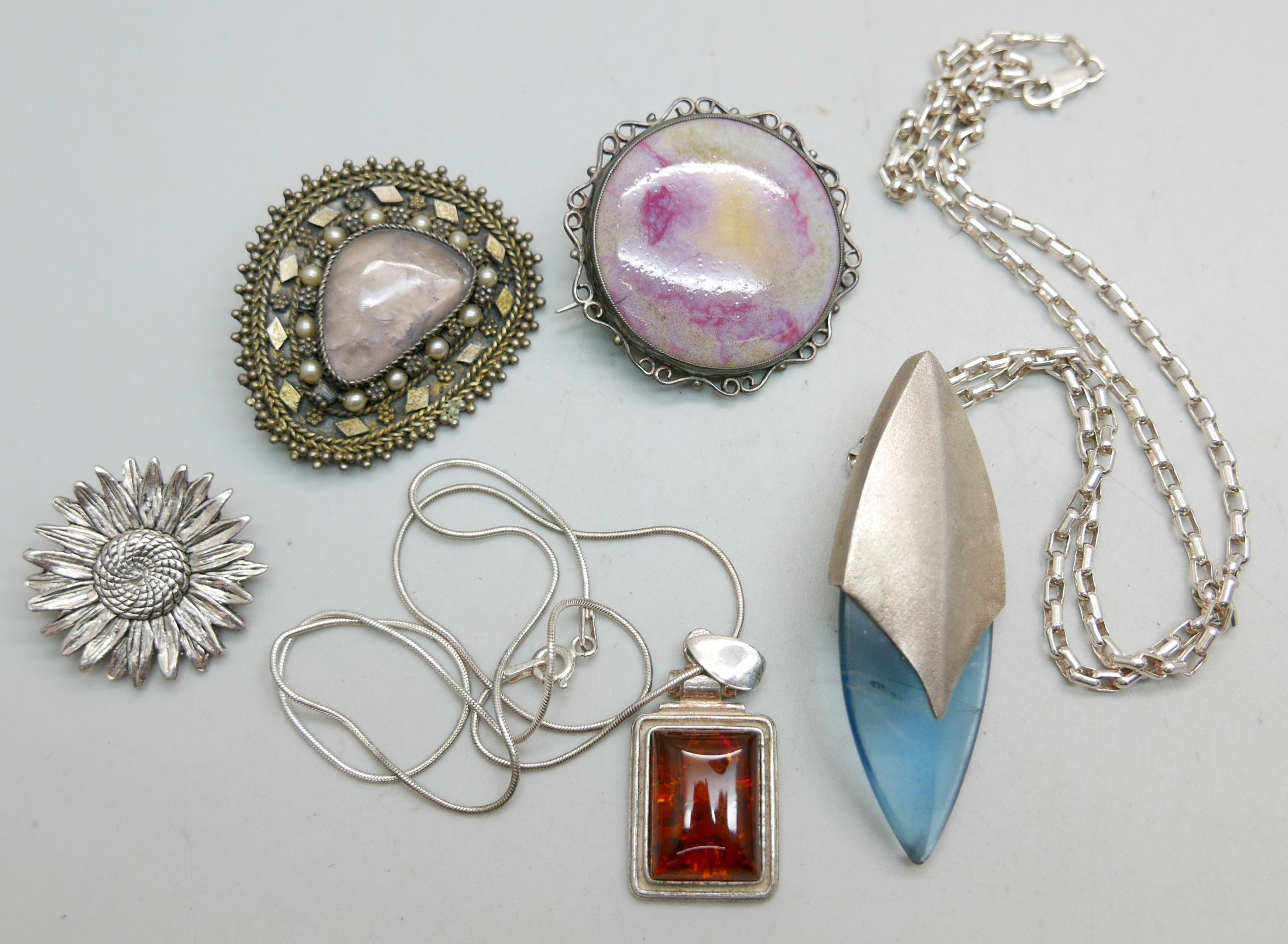 Three brooches and two pendants on silver chains