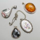 A hallmarked silver Coalport plaque pendant, a silver and amber coloured pendant, and two other