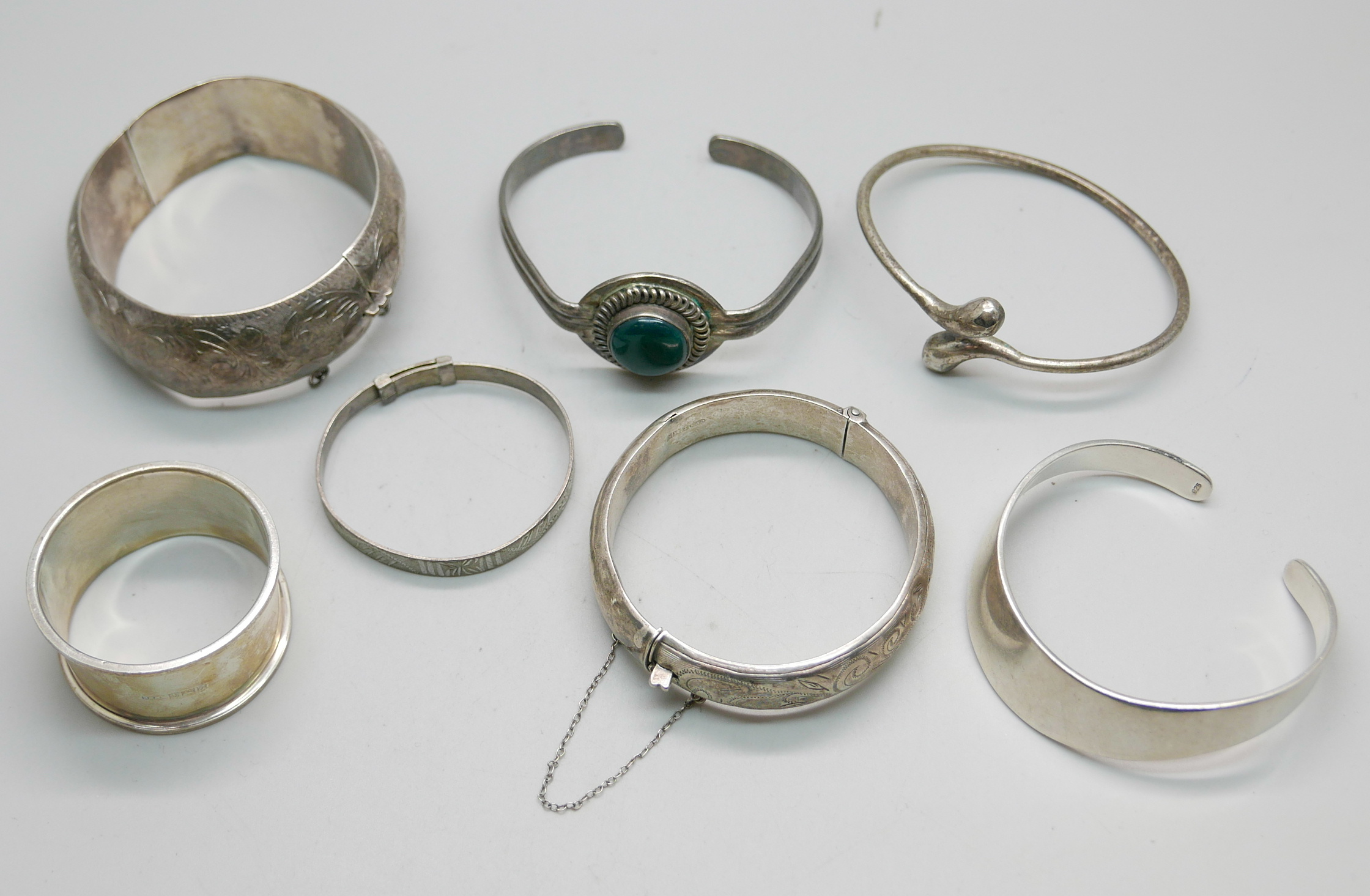 Six silver bangles and a silver napkin ring, 158g