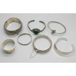 Six silver bangles and a silver napkin ring, 158g