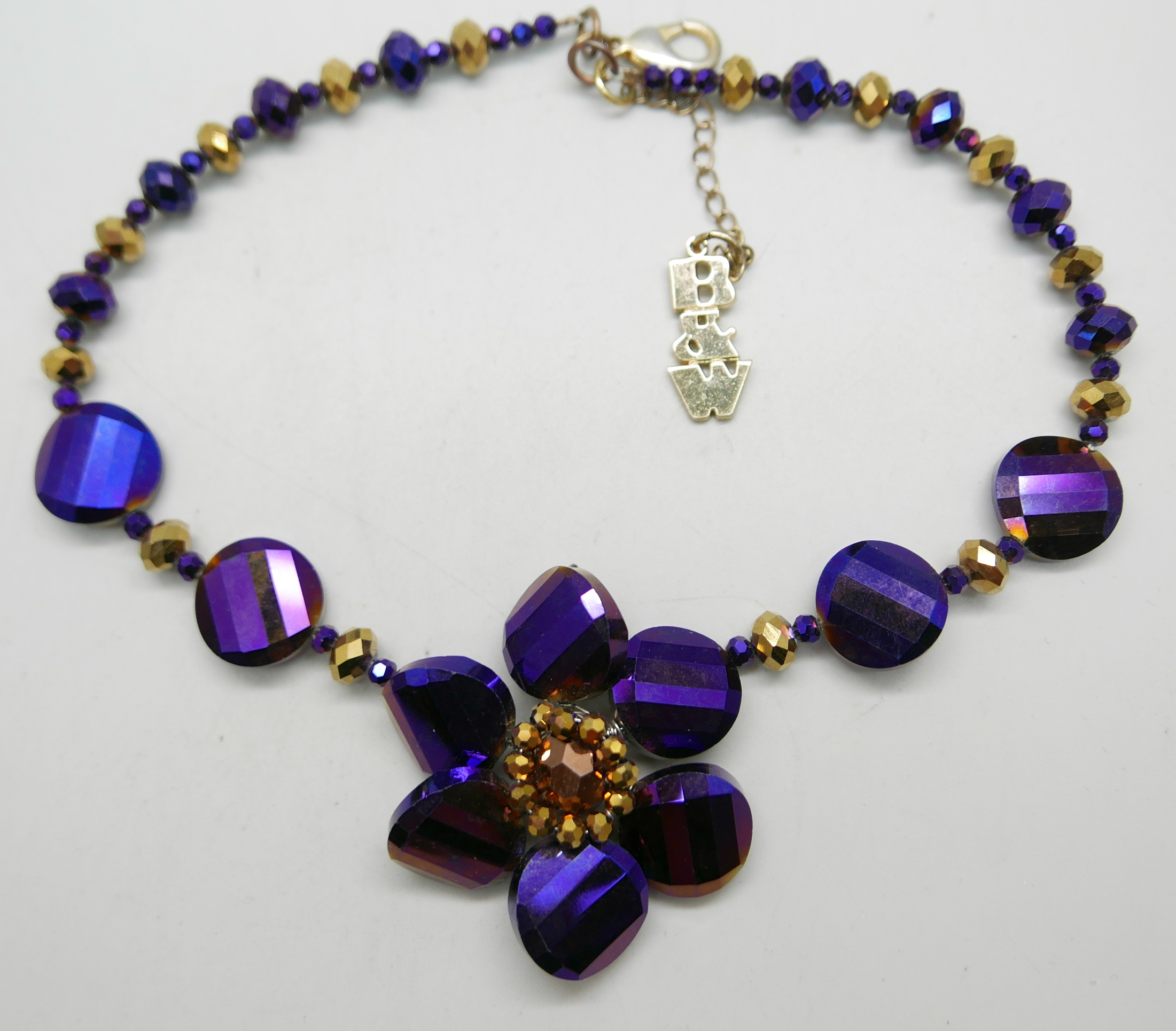 A Butler and Wilson Purple and Gold necklace and a Joules rhinestone three flower necklace - Image 2 of 3