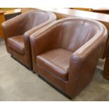 A pair of brown leather tub chairs